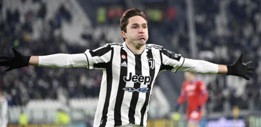 Federico Chiesa celebrating a goal with his arms spread wide